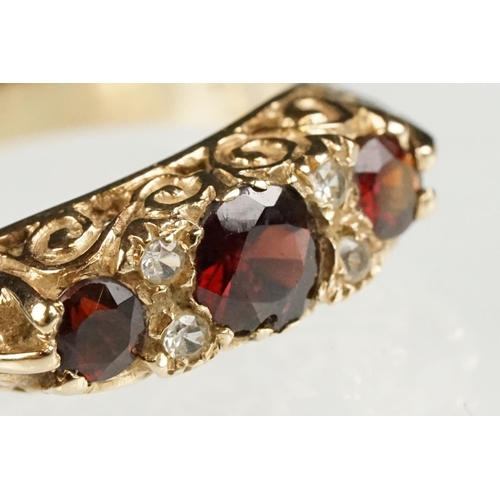 117 - Garnet 9ct yellow gold boat head ring, three graduated round mixed cut rubies, the principal ruby di... 