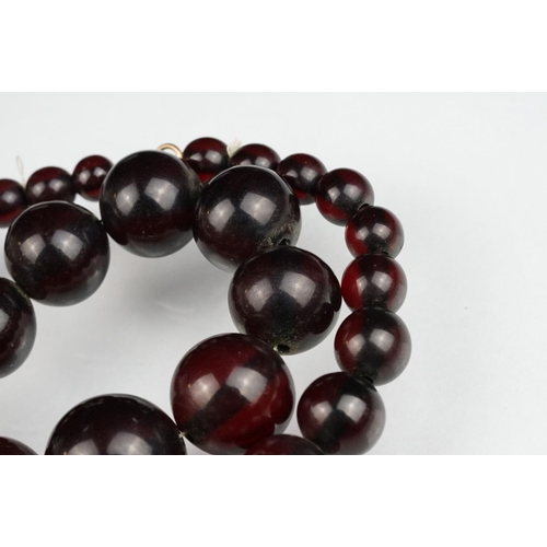 51 - Cherry amber Bakelite graduated bead necklace, sixty four oval beads, the largest measuring approx 3... 