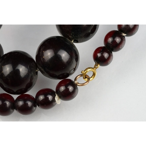 51 - Cherry amber Bakelite graduated bead necklace, sixty four oval beads, the largest measuring approx 3... 