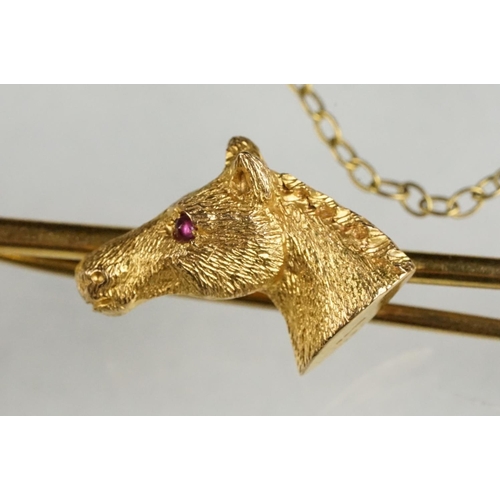 78 - 9ct yellow gold bar brooch with platinum mounts, modelled as a horse head with a small cabochon ruby... 