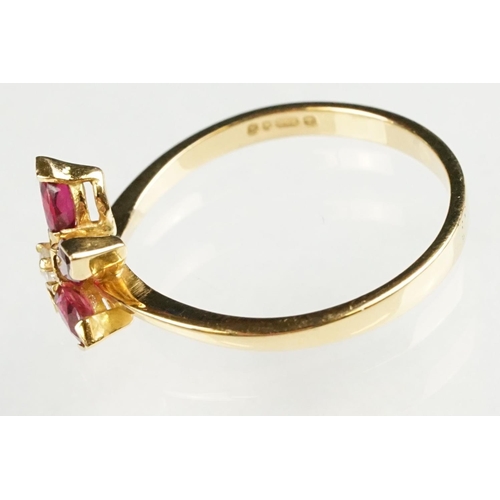 80 - Ruby and diamond 18ct yellow gold ring, three marquise cut rubies, claw set, the principal ruby meas... 