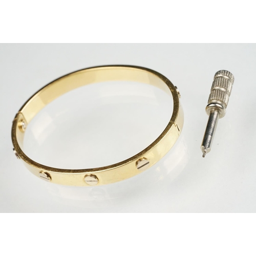 89 - 18ct yellow and white gold hinged band, screw head decoration, the fastening modelled as a screw, wi... 