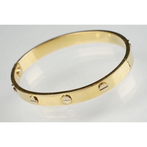 89 - 18ct yellow and white gold hinged band, screw head decoration, the fastening modelled as a screw, wi... 