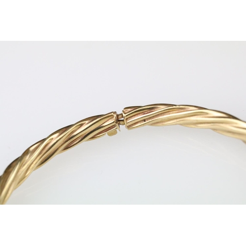 11 - 9ct yellow gold writhen twist hinged bangle together with a rose, yellow and white metal bangle (2)