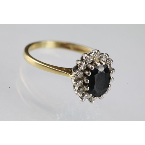 16 - Sapphire and diamond 18ct yellow gold cluster ring, blue-black oval mixed cut sapphire, small round ... 