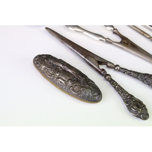 659 - Silver handled items to include two pairs of glove stretchers, a shoe horn, four button hooks, Irish... 