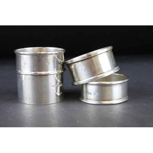 811 - Three silver hallmarked napkin rings and a silver hallmarked egg cup. The egg cup having a gilt inte... 