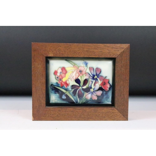 6 - Four Moorcroft ceramic framed mounted ceramic lids to include a hibiscus pattern plaque, two clemati... 