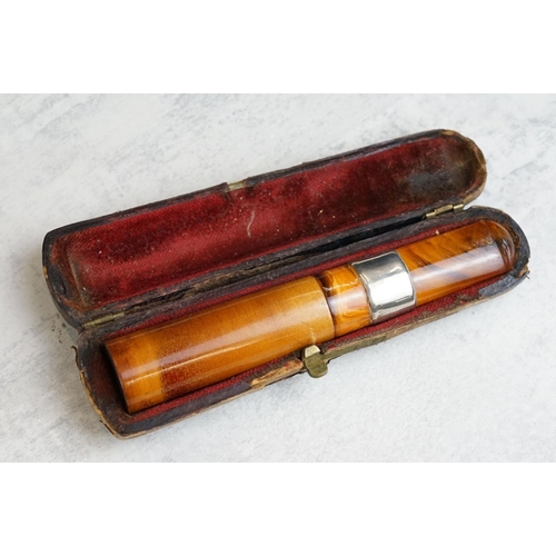 217 - A collection of seven amber cheroot holders to include some with silver mounts, all contained within... 