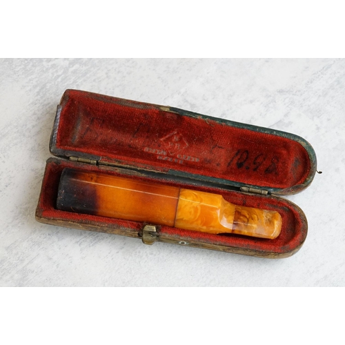 217 - A collection of seven amber cheroot holders to include some with silver mounts, all contained within... 