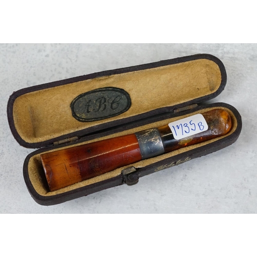 217 - A collection of seven amber cheroot holders to include some with silver mounts, all contained within... 