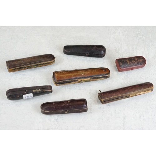 217 - A collection of seven amber cheroot holders to include some with silver mounts, all contained within... 