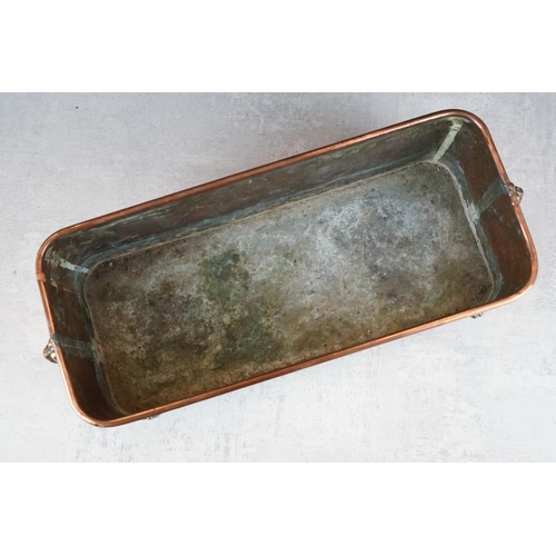 120 - Copper planter of rectangular form, with rolled upper rim, twin lion mask loop handles, raised on fo... 