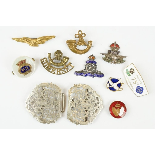 352 - An antique silver plated nurses belt buckle together with a quantity of badges to include military e... 