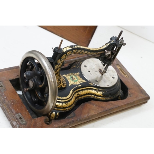 436 - Victorian cast iron table top sewing machine with typical gilt decoration, approx 36cm long, wooden ... 