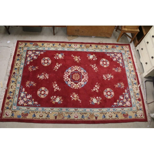 711 - Large Chinese style Red Ground Rug decorated with flowers within a pale green border decorated with ... 