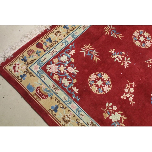 711 - Large Chinese style Red Ground Rug decorated with flowers within a pale green border decorated with ... 