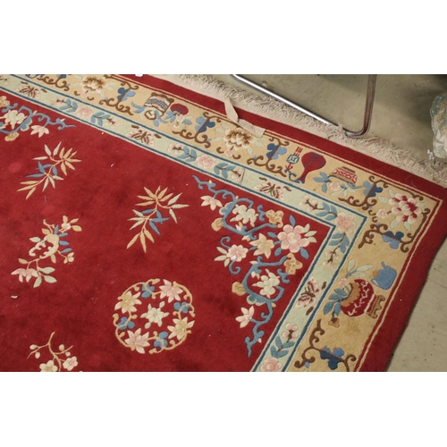 711 - Large Chinese style Red Ground Rug decorated with flowers within a pale green border decorated with ... 