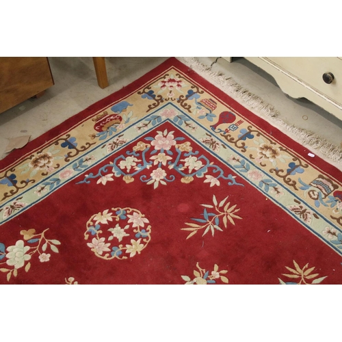 711 - Large Chinese style Red Ground Rug decorated with flowers within a pale green border decorated with ... 