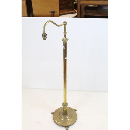 702 - Late 19th / Early 20th century Brass Standard Reading Lamp, the circular base with three scroll feet