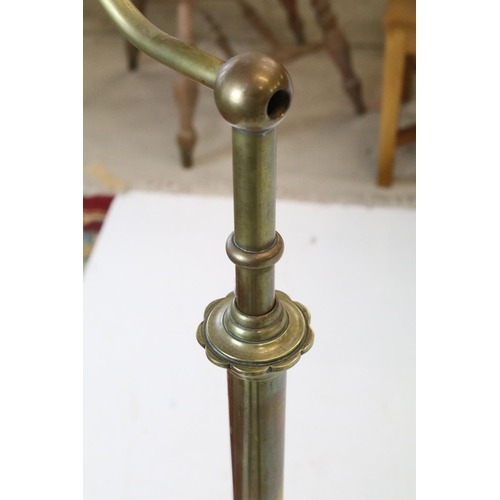 702 - Late 19th / Early 20th century Brass Standard Reading Lamp, the circular base with three scroll feet