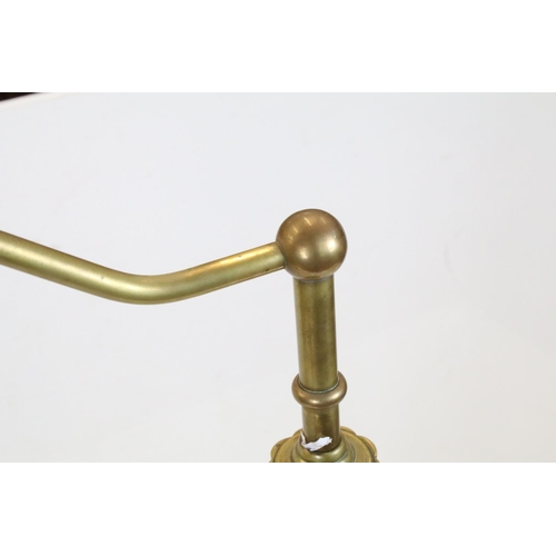 702 - Late 19th / Early 20th century Brass Standard Reading Lamp, the circular base with three scroll feet