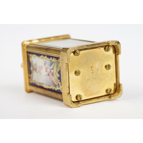 232 - A miniature antique brass cased carriage clock with enamel panels with cherub decoration.