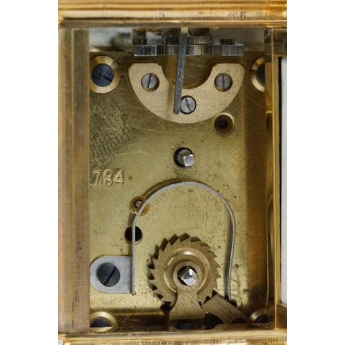 232 - A miniature antique brass cased carriage clock with enamel panels with cherub decoration.