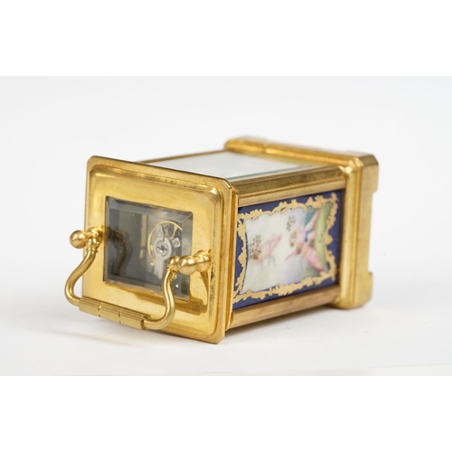 232 - A miniature antique brass cased carriage clock with enamel panels with cherub decoration.