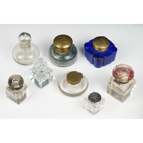 311 - A collection of eight vintage glass inkwells to include a blue glass example.