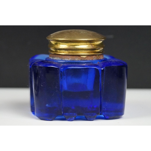 311 - A collection of eight vintage glass inkwells to include a blue glass example.