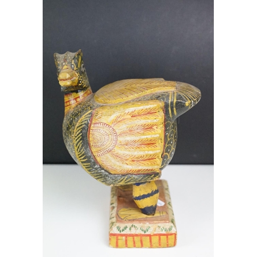 184 - South East Asian carved wooden duck sculpture with painted decoration, raised on a rectangular base.... 