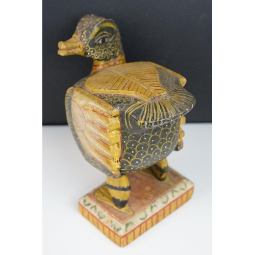 184 - South East Asian carved wooden duck sculpture with painted decoration, raised on a rectangular base.... 