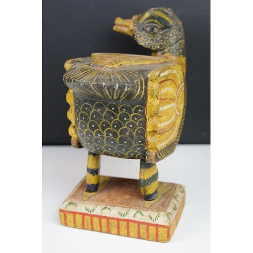 184 - South East Asian carved wooden duck sculpture with painted decoration, raised on a rectangular base.... 