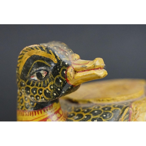 184 - South East Asian carved wooden duck sculpture with painted decoration, raised on a rectangular base.... 