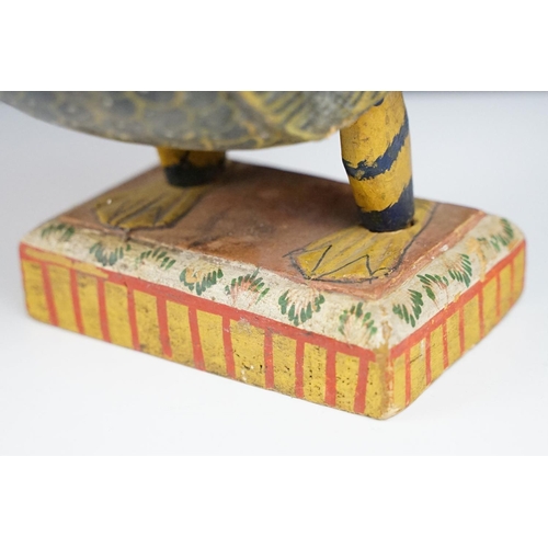 184 - South East Asian carved wooden duck sculpture with painted decoration, raised on a rectangular base.... 