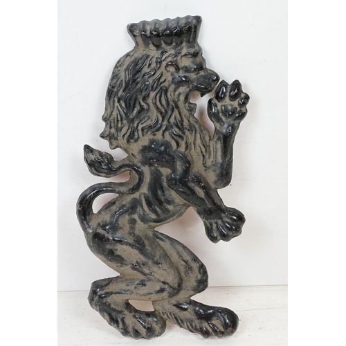 186 - Pair of cast iron rampant lion black painted wall plaques, approx 55cm tall