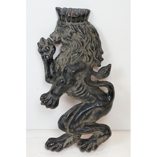 186 - Pair of cast iron rampant lion black painted wall plaques, approx 55cm tall