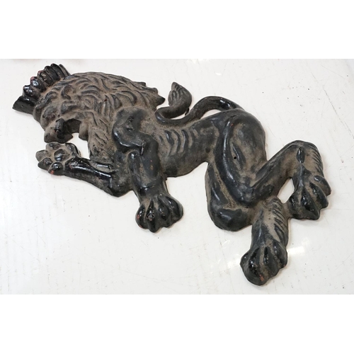 186 - Pair of cast iron rampant lion black painted wall plaques, approx 55cm tall