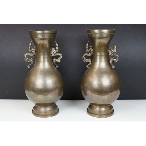 187 - Pair of 20th Century Chinese bronze vases having engraved bird and cloud detailing, each having twin... 