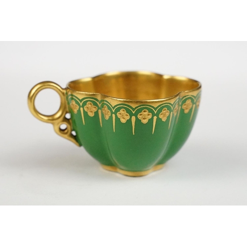 74 - Coalport miniature cabinet cup & saucer, of quatrefoil design, with gilt decoration on a green groun... 