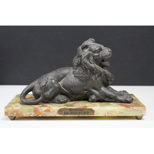 168 - 'Souvenir de Belfort' spelter figure of a recumbent lion, raised on a rectangular onyx base, 22cm wi... 