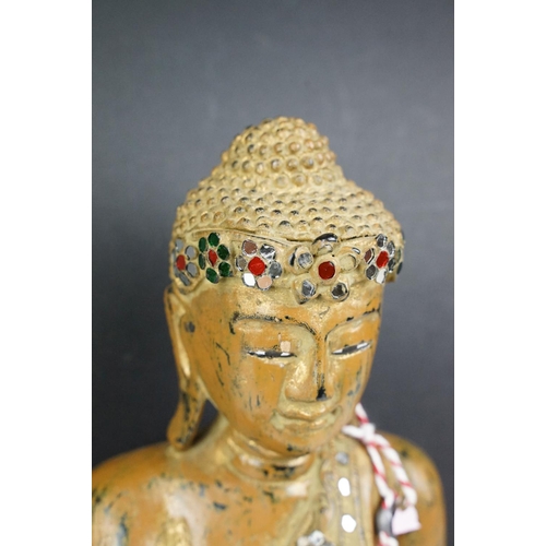 182 - Carved wooden figure of a Thai seated Buddha, with serene facial expression, sequinned & gilt detail... 