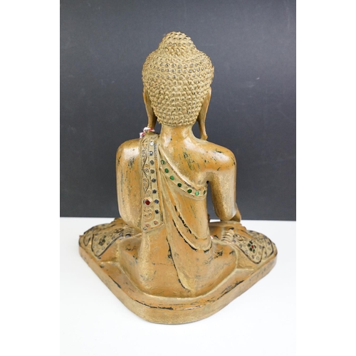 182 - Carved wooden figure of a Thai seated Buddha, with serene facial expression, sequinned & gilt detail... 