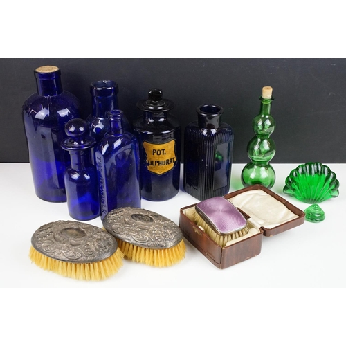 346 - A small group of collectables to include glass medicine bottles, two hallmarked silver clothes brush... 