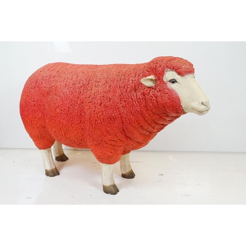 166 - Large painted fibreglass model of a sheep, in red & white. Measures approx 65cm H x 100cm L