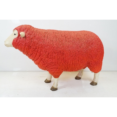 166 - Large painted fibreglass model of a sheep, in red & white. Measures approx 65cm H x 100cm L