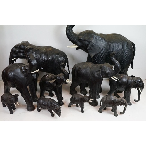 438 - Group of nine Liberty style leather bound elephants with glass eyes, of varying size (tallest approx... 