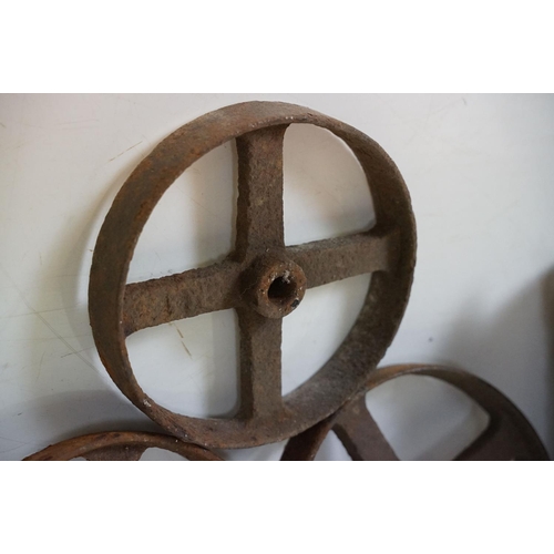 433 - Red painted metal fire bucket containing four cast iron spoked wheels (approx 23.5cm diameter), toge... 