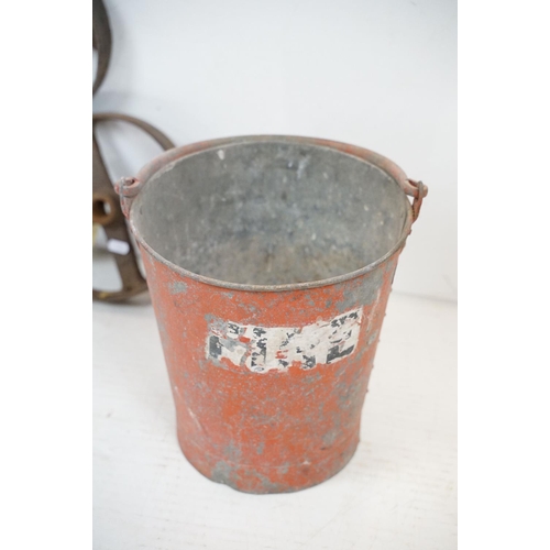 433 - Red painted metal fire bucket containing four cast iron spoked wheels (approx 23.5cm diameter), toge... 